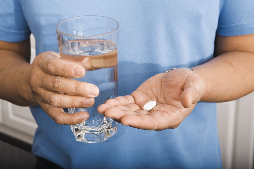 um homem bebendo uma pílula para parasitas